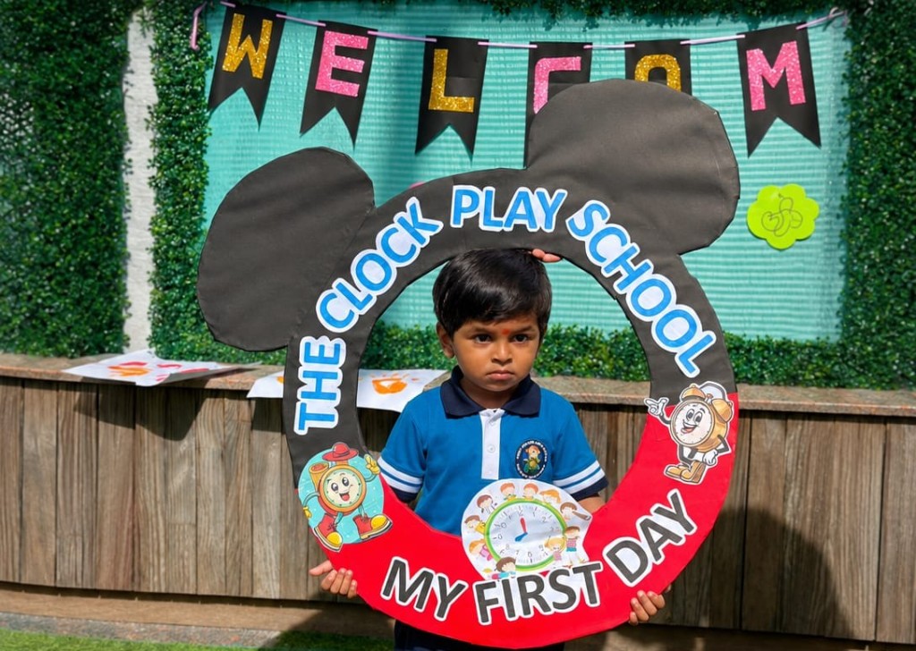 Child holding 'My First Day' Mickey frame at The Clock Play School
